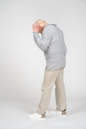 Side view of a man walking and hiding his face