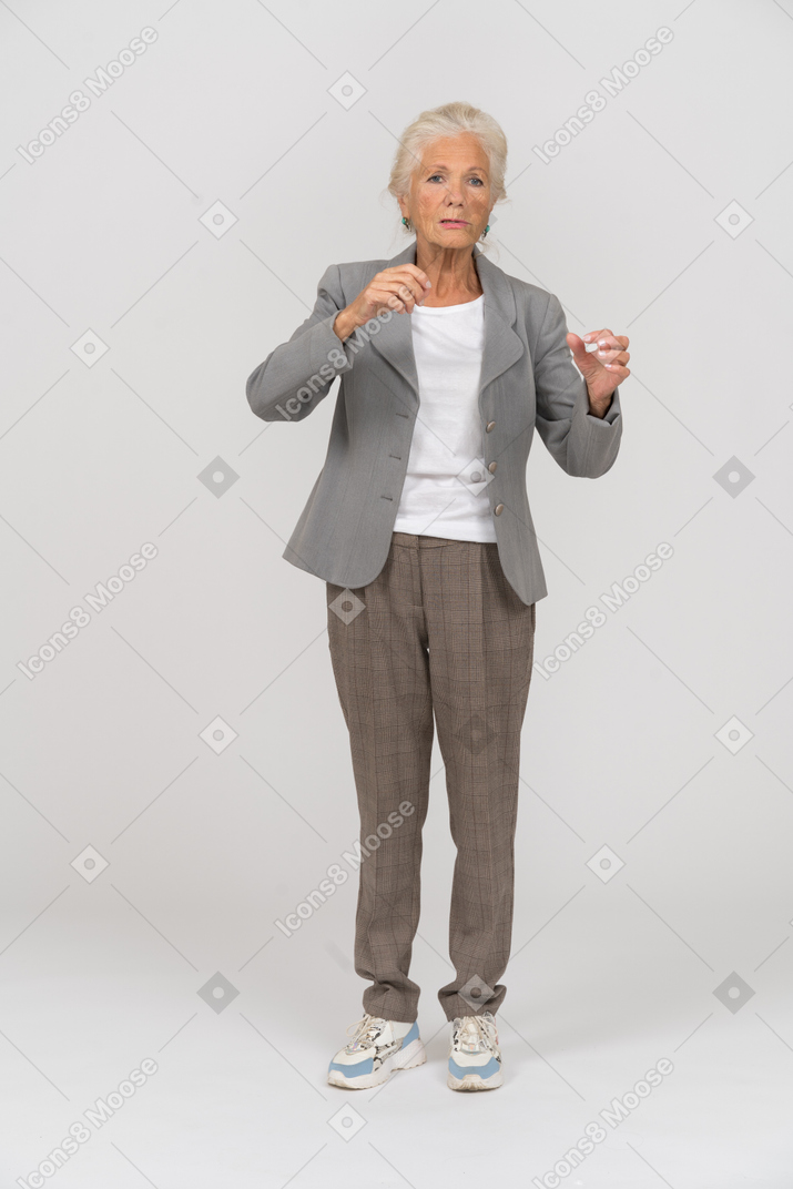Front view of an old lady in suit waving hands
