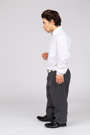 Вид в профиль серьезного мужчины в формальной одежде, отводящего взгляд