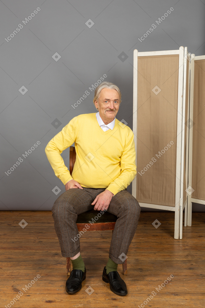 Улыбающийся мужчина средних лет смотрит в камеру