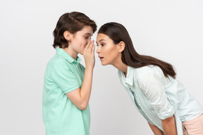 Attractive boy sharing a secret with his mother