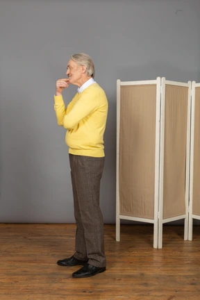 Side view of thoughtful old man touching chin