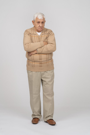Vista frontal de um velho em roupas casuais em pé com os braços cruzados e olhando para a câmera