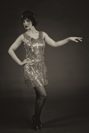 Woman in sequin dress posing in the dark