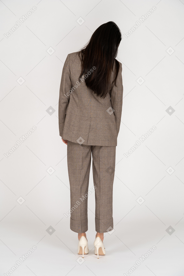 Vista posteriore di una giovane donna in tailleur marrone inclinando la testa
