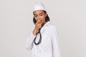 Atraente jovem médico feminino segurando um estetoscópio