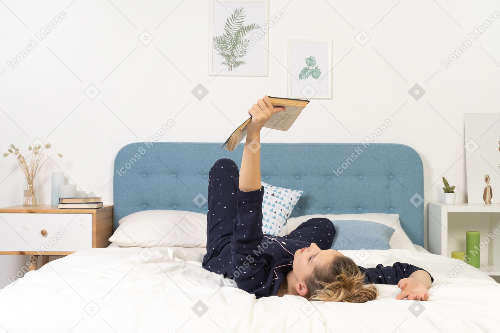 Full-length of a bored young lady trying to read book in bed
