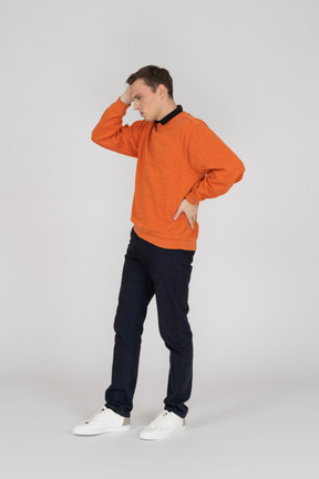 Jeune homme en sweat-shirt orange debout