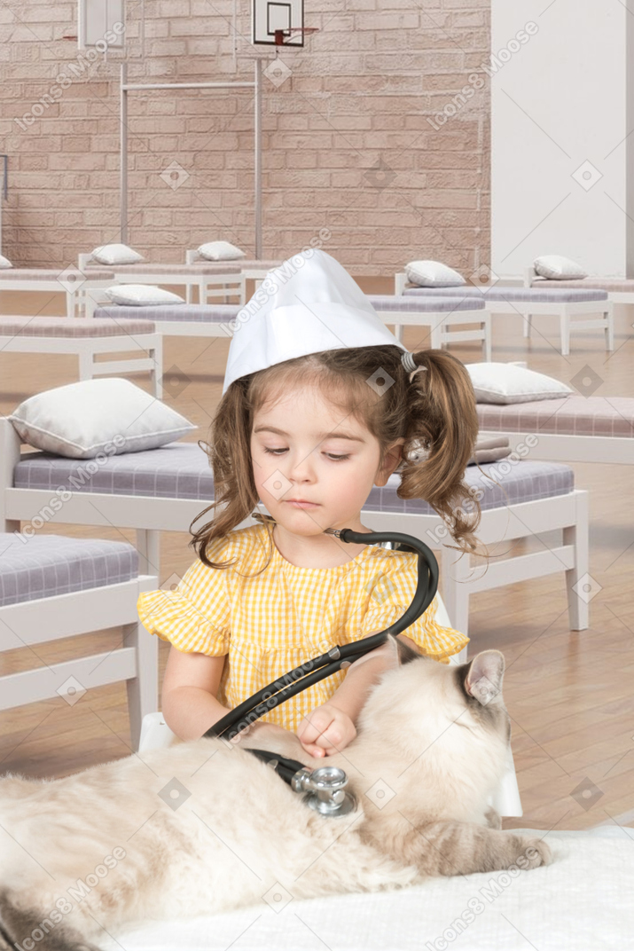 Ein kleines mädchen spielt mit ihrer katze im provisorischen krankenhaus