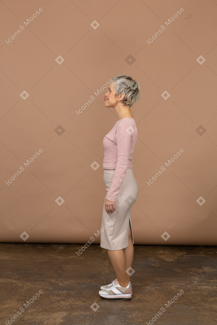 Frau in freizeitkleidung posiert im profil und macht gesichter