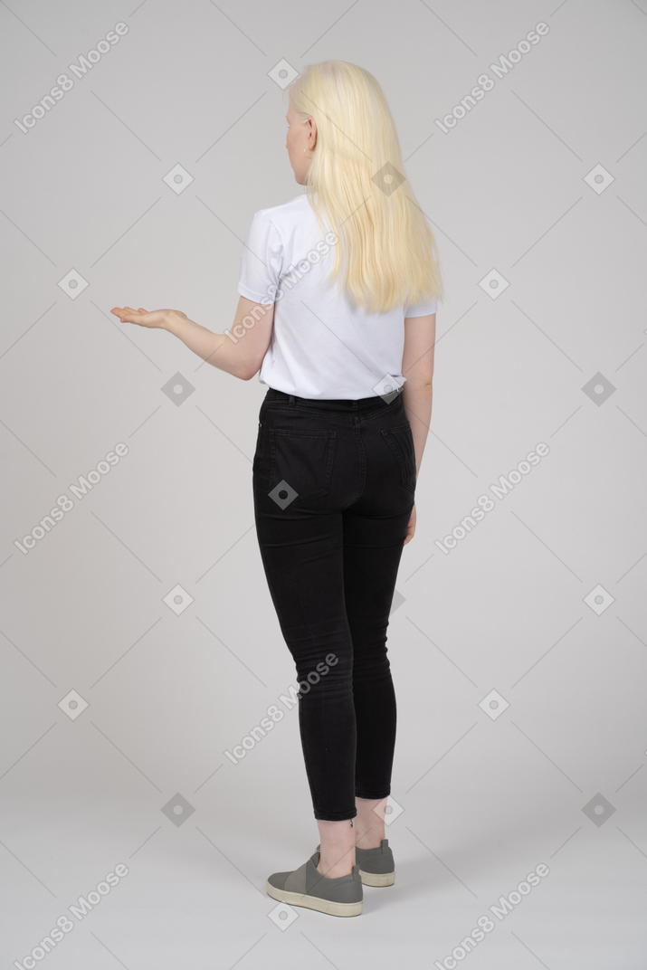 Back view of a young woman holding out her hand