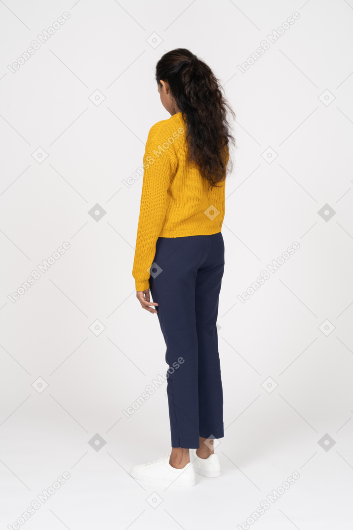 Rear view of a girl in casual clothes looking down