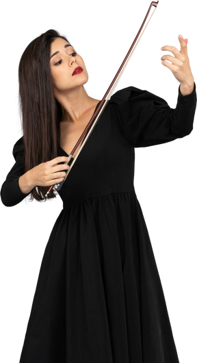 Front view of a young lady in black dress making an impression of playing the violin