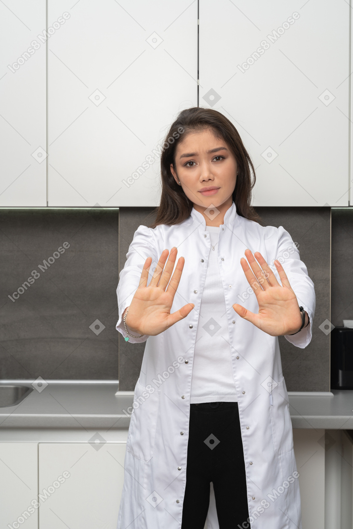 一个女护士用两只手显示停止手势的特写