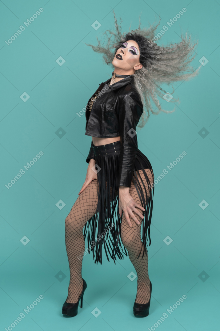 Drag queen in all black outfit leaning on knees