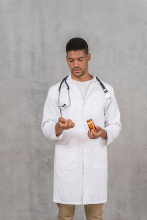 Male doctor looking at pills