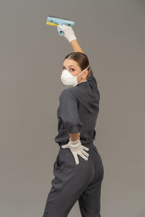 Rear view of a woman looking over shoulder while cleaning