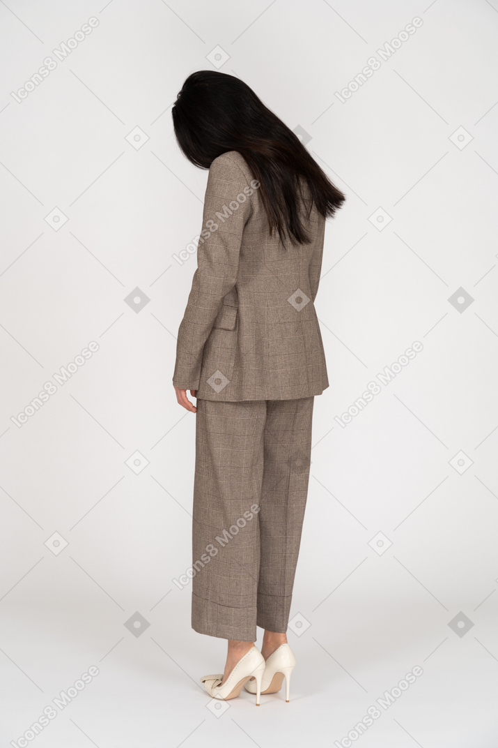 Vista posteriore di tre quarti di una giovane donna in tailleur marrone guardando verso il basso