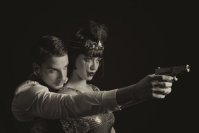 Man helping a flapper aiming the gun