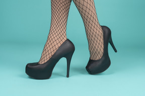 Close-up of legs in fishnets and high heels
