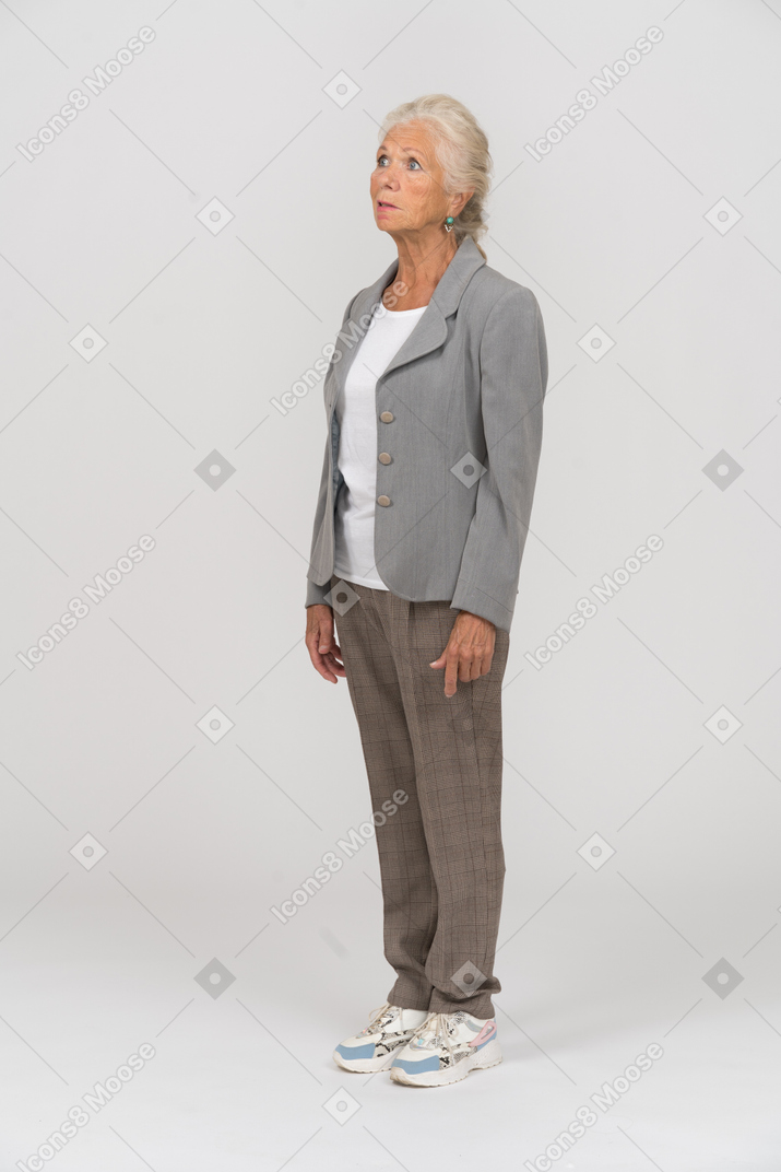Vista laterale di una vecchia signora in abito che pensa a qualcosa
