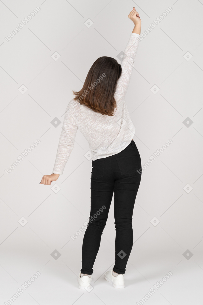 Vista posteriore di una giovane donna indiana risvegliata in abiti casual che allunga le braccia