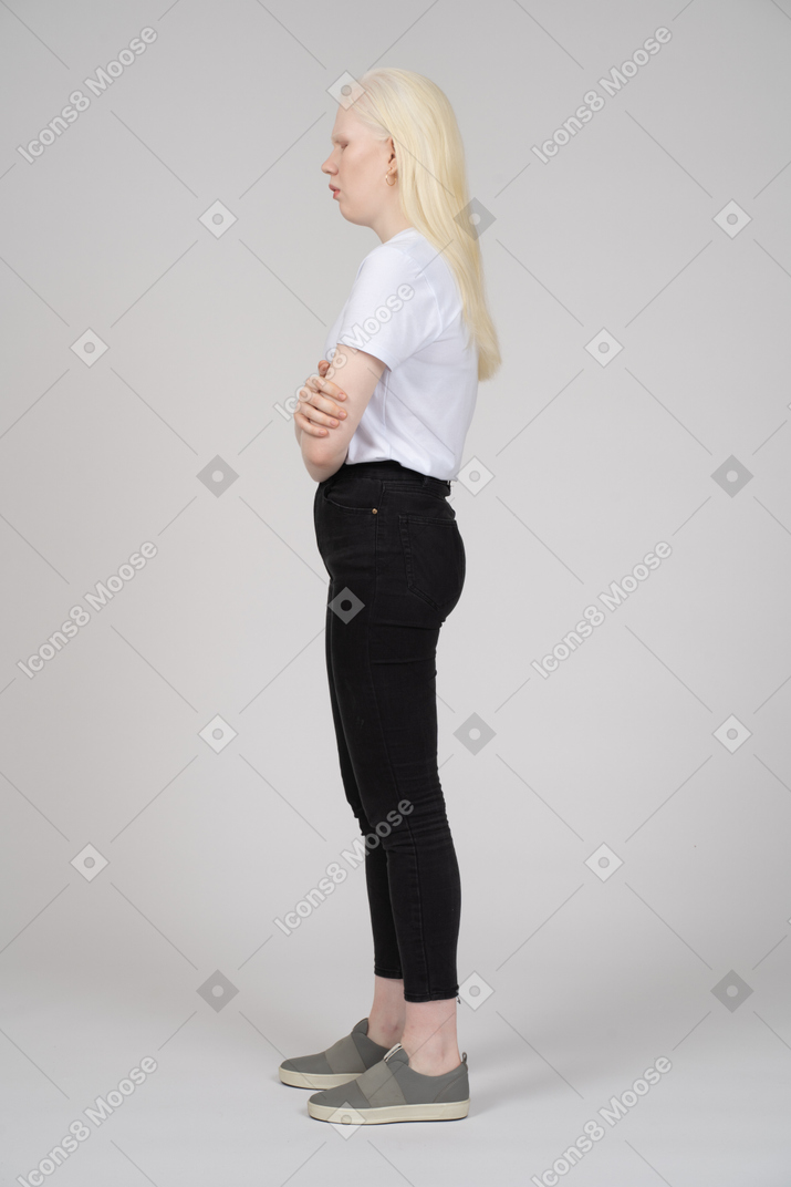 Side view of a blonde girl holding herself