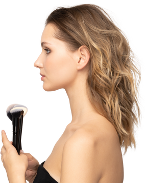 Side view of a sensual young woman holding make-up brushes