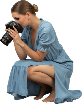 一位身穿蓝色连衣裙的年轻女子坐在地板上拍摄的四分之三视图