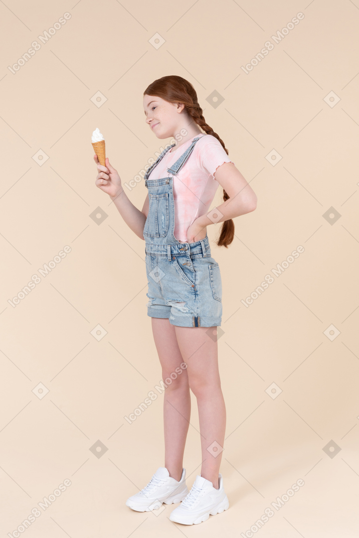 Teenager girl looking at ice cream she's holding