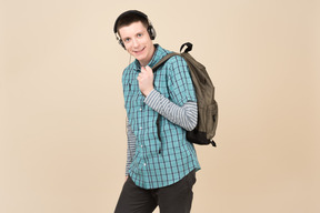 Student standing with a backpack and headphones