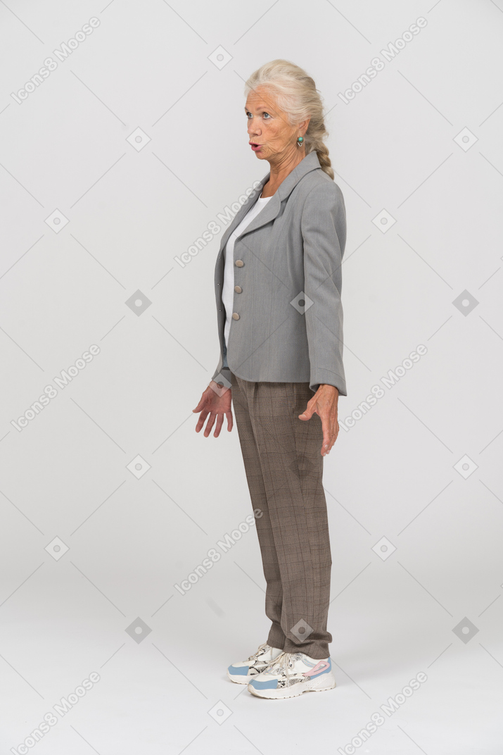 Wütende alte dame im anzug, die im profil steht