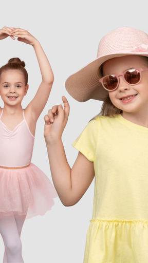 Little girl standing in ballet position next to little girl with hat and sunglasses