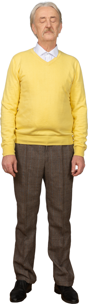 Vista frontale di un vecchio che indossa un maglione giallo e in piedi ancora con gli occhi chiusi