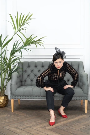 Woman in blouse sitting in a menacing pose