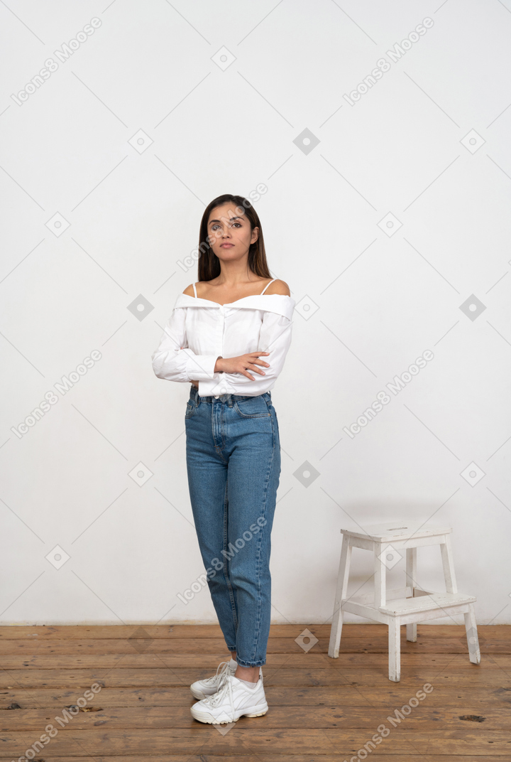 Young woman in casual clothes standing with crossed arms