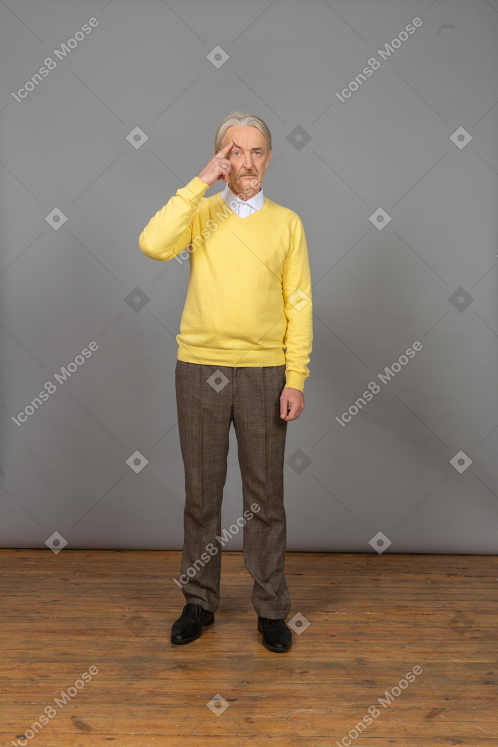 体贴的老人，穿着黄色的套衫，摸额头的前视图
