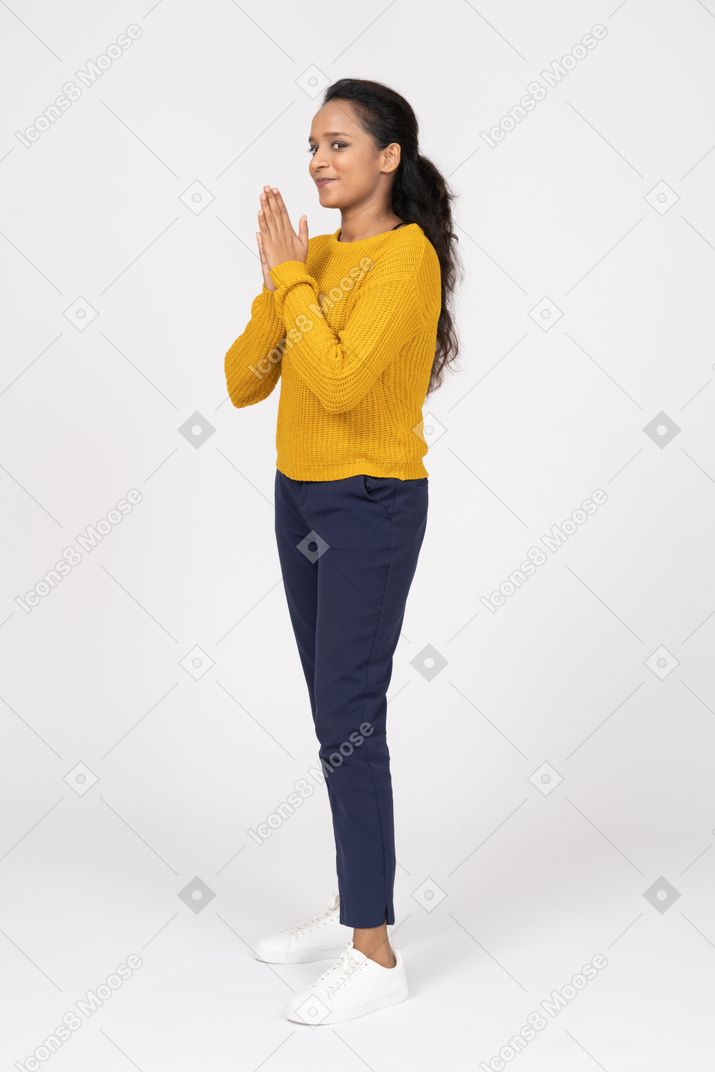 Side view of a happy girl in casual clothes rubbing hands