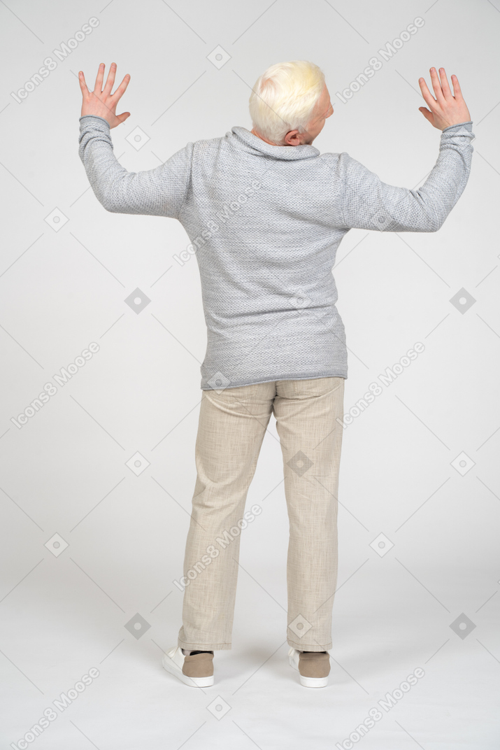 Rear view of man standing with hands up