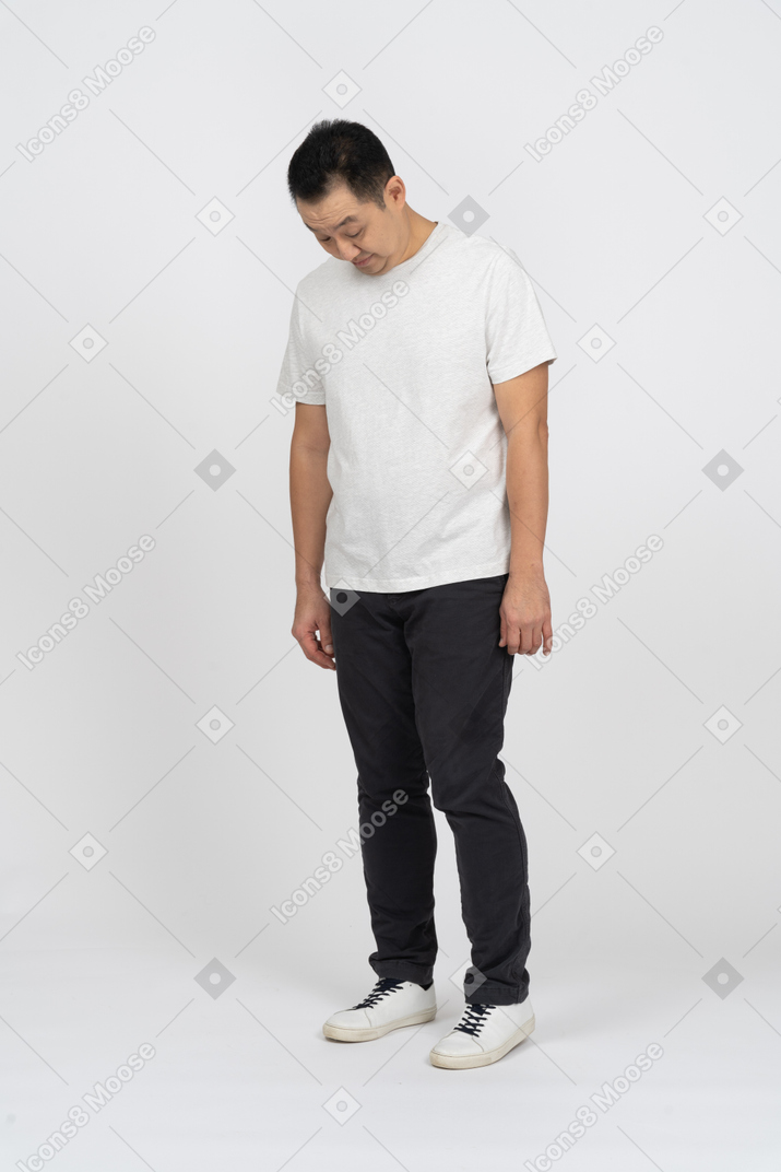 一个穿着休闲服的男人低着头站着的正面图