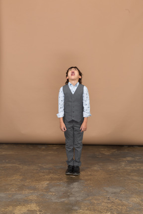 Front view of a boy in suit looking up