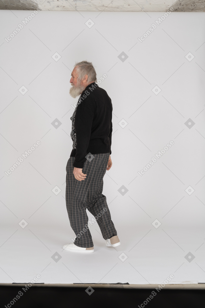 Side view of elderly man walking with arms at sides
