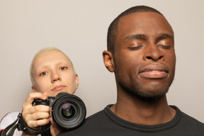 Young woman taking a picture of man