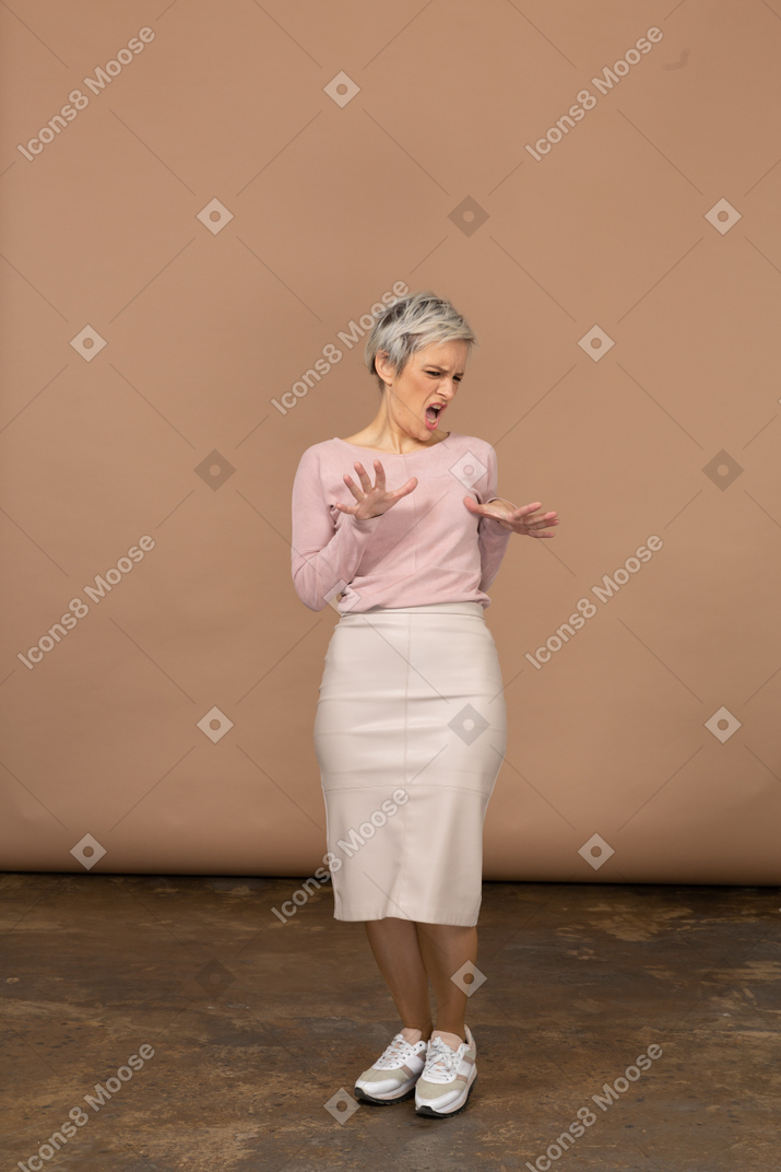 一个穿着休闲服的情绪化女人的前视图，显示停止手势