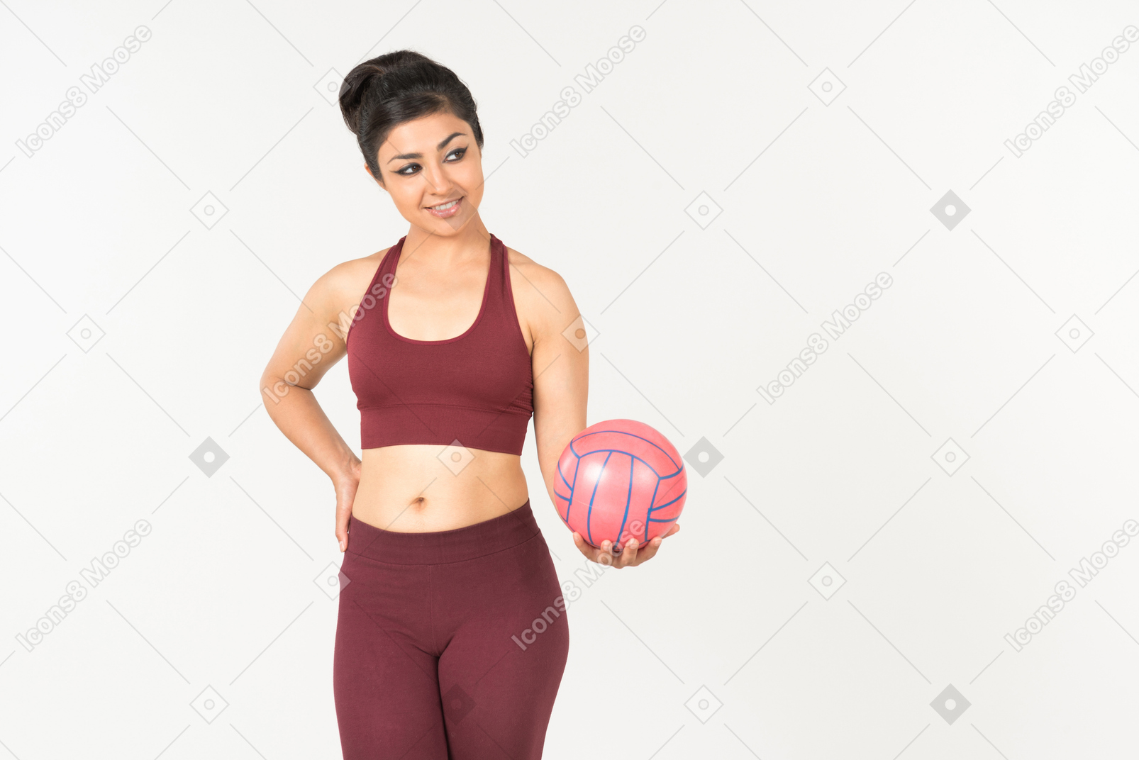 Smiling young indian woman holding pink ball