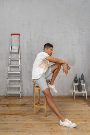 Side view of thinking man sitting on chair