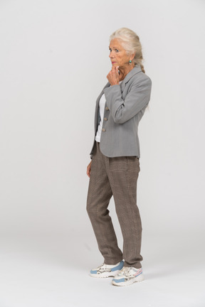Side view of a thoughtful old lady in suit