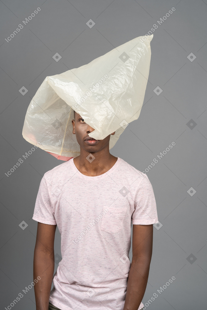 Close-up unemotional african male with a plastic pocket hiding his face