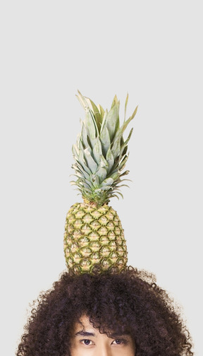 A man with afro hair and a pineapple on his head