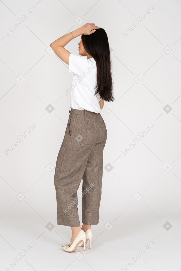 Vue latérale d'une jeune femme en culotte et t-shirt touchant sa tête